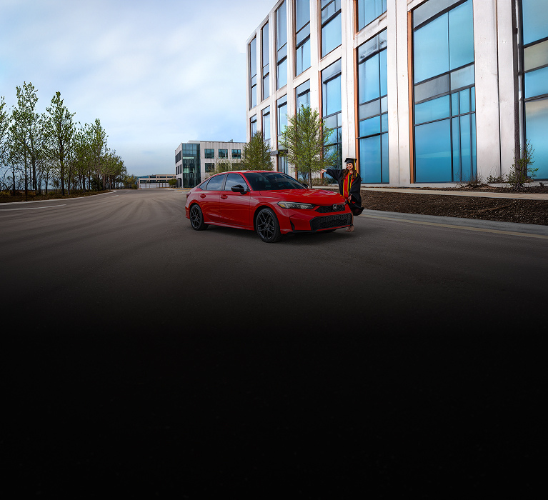 2026 Honda Civic Sedan Civic Sport Sedan in Rallye Red  front parked on a road with a graduate (Compact Sedan).