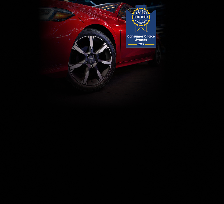 2025 Honda Civic Sedan Sport Touring Hybrid in Rallye Red profile in a dark studio with the Kelley Blue Book award (Compact Sedan).